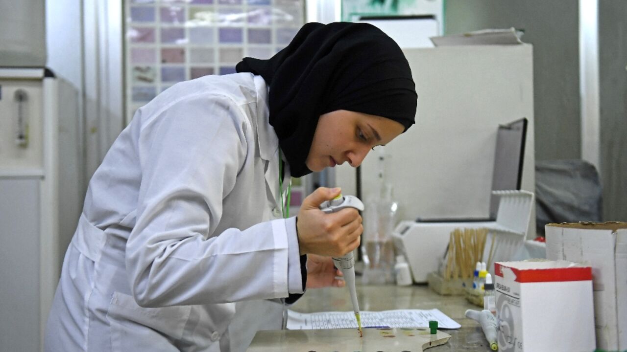 A lab technician tests samples for cholera at a hospital in Syria's main northern city of Aleppo