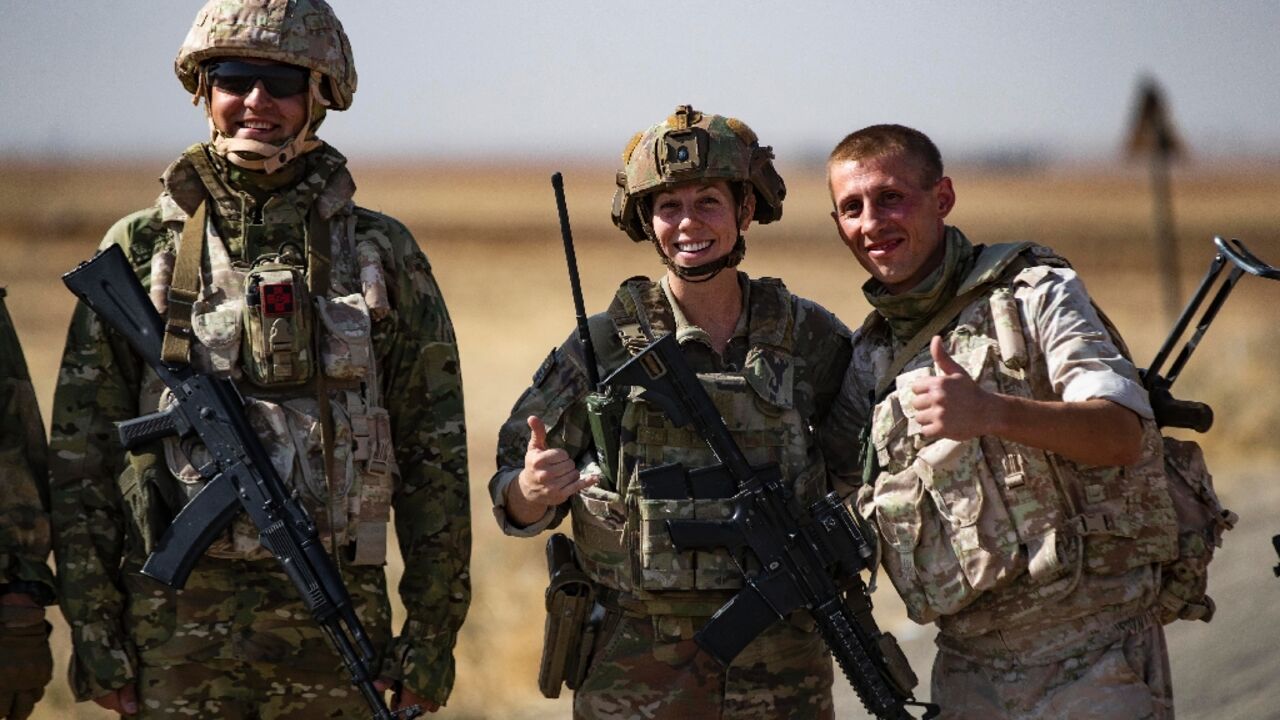 Rival Russian and US soldiers stood side by side as they spoke and posed for pictures