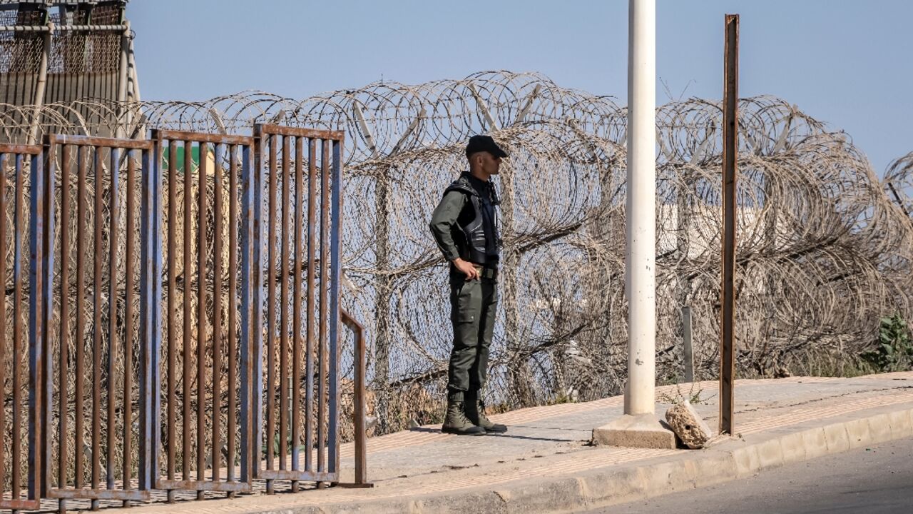 A Moroccan security officer stands guard on the border fence with Spain's North African Melilla enclave