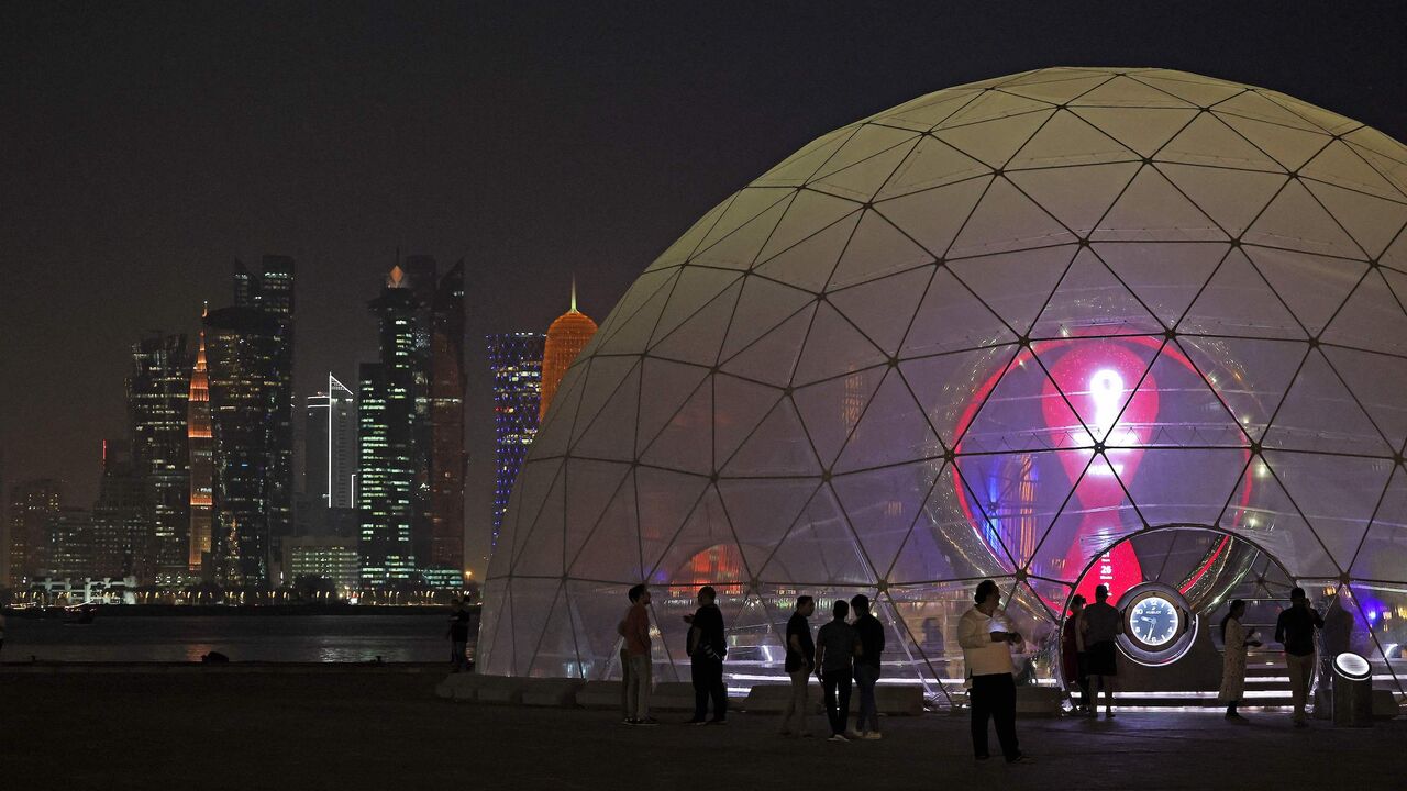 People gather next to the Qatar 2022 FIFA World Cup countdown clock in Doha, on Sept. 12, 2022. 