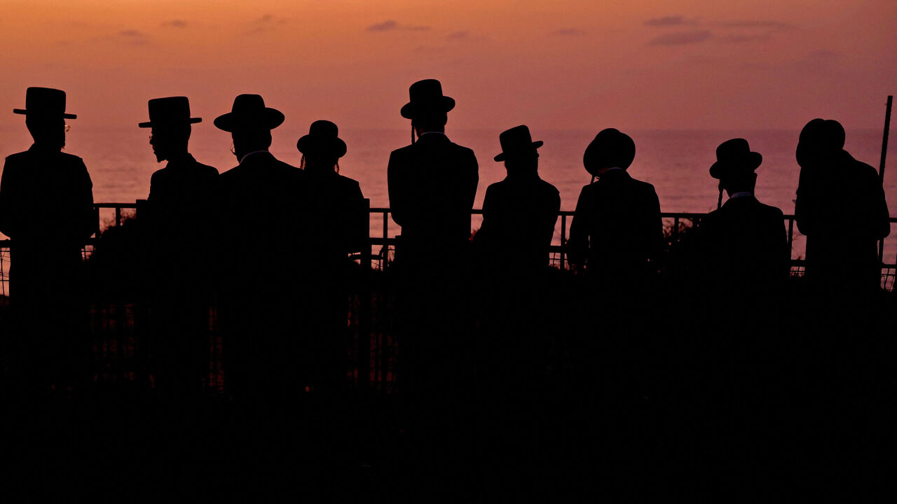Ultra-Orthodox Jewish men and children perform the "Tashlich" ritual, during which "sins are cast into the water to the fish," ahead of the Day of Atonement (Yom Kippur), Netanya, Israel, Oct. 3, 2022.