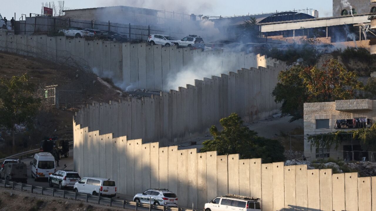 Smoke billows as Israeli security forces conduct a manhunt following a shooting attack, in the Palestinian Shuafat refugee camp by the separation barrier in Israeli-annexed east Jerusalem
