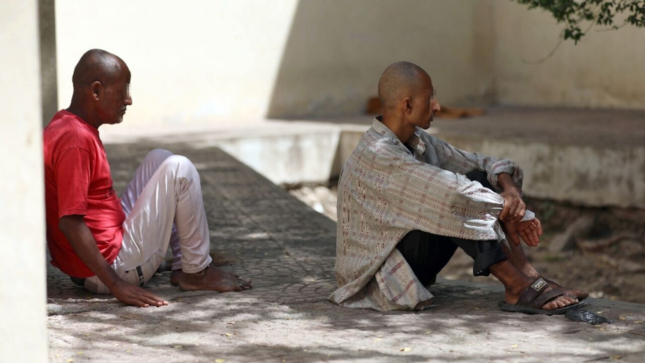 Patients at a psychiatric hospital sit outdoors in the shade in Yemen's third city of Taez