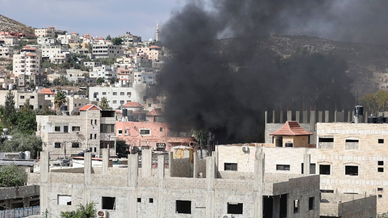 Smoke billows over the flashpoint West Bank city of Jenin as Israeli troops mount an incursion to arrest a wanted suspect, killing two Palestinians, according to the health ministry