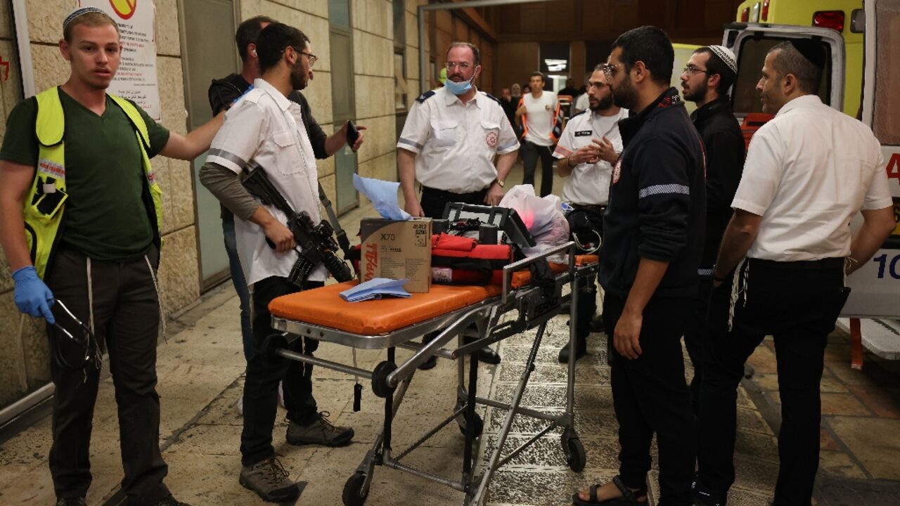 Israeli first responders gather outside the Hadassah Ein Kerem Hospital in Jerusalem following the attack in Hebron