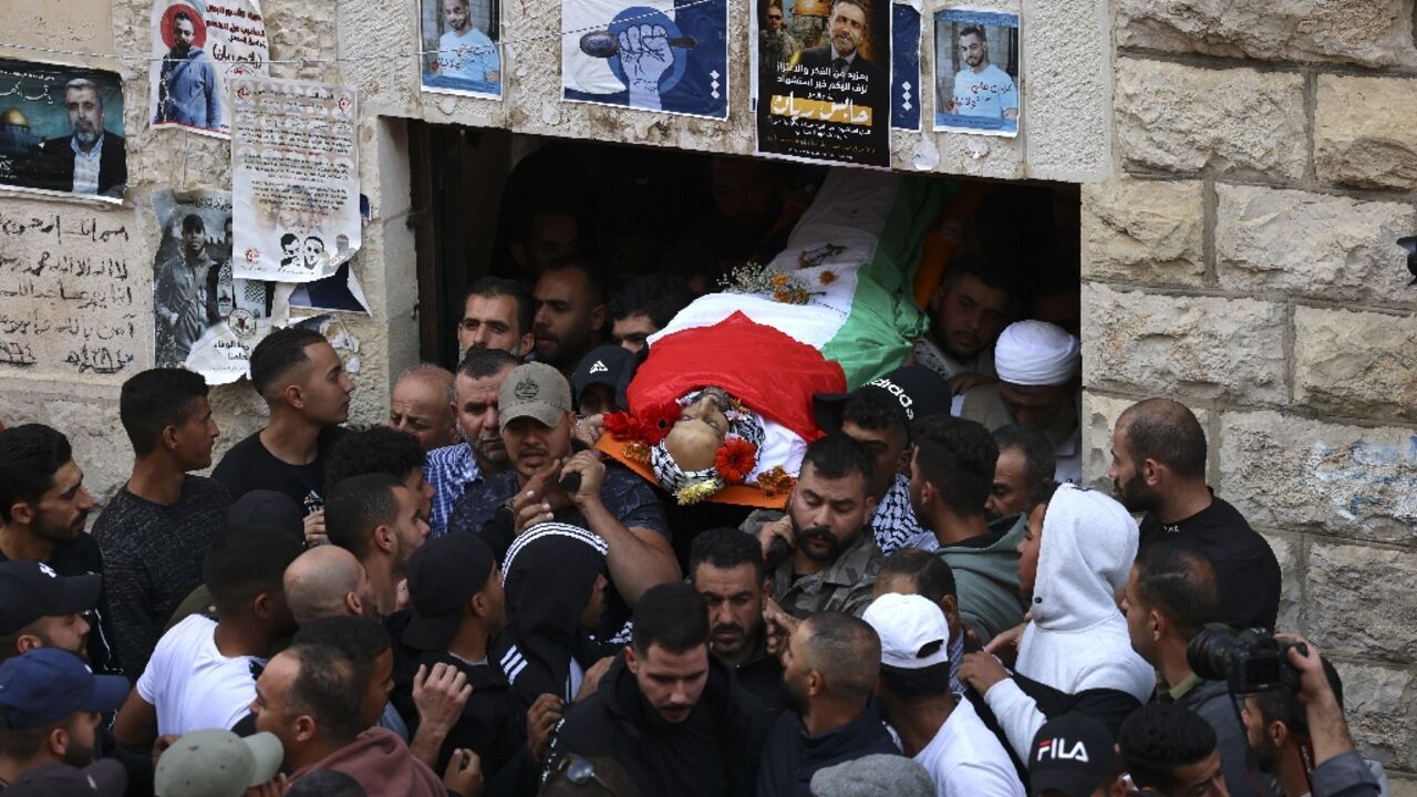 Mourners carry the body of a Palestinian man killed during confrontations with Israeli forces in the village of Beit Beit Duqqu northwest of Jerusalem