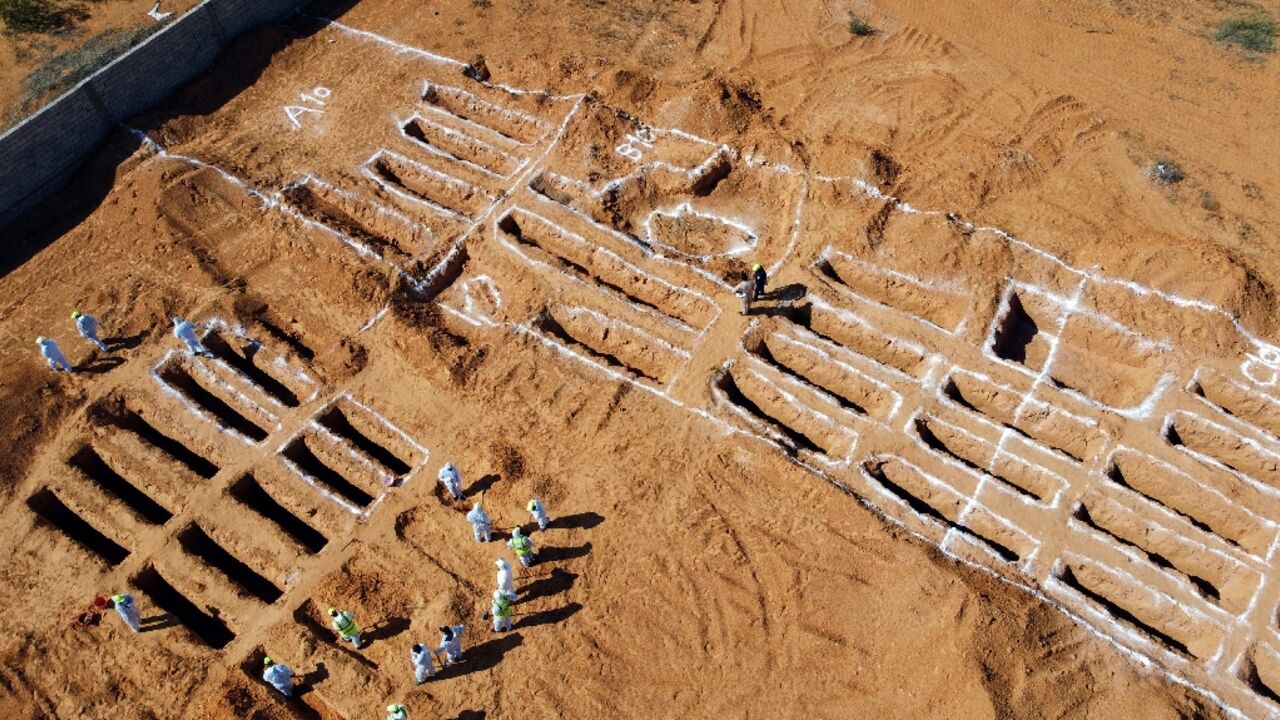 An aerial view shows Libyan experts exhuming human remains from mass graves in Tarhuna, southeast of the capital Tripoli, on October 28, 2020