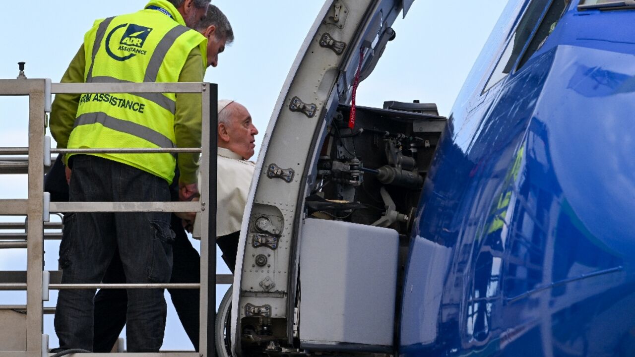 Pope Francis, seated on a wheelchair, boards a plane at Fiumicino airport to leave on a four-day trip to Bahrain