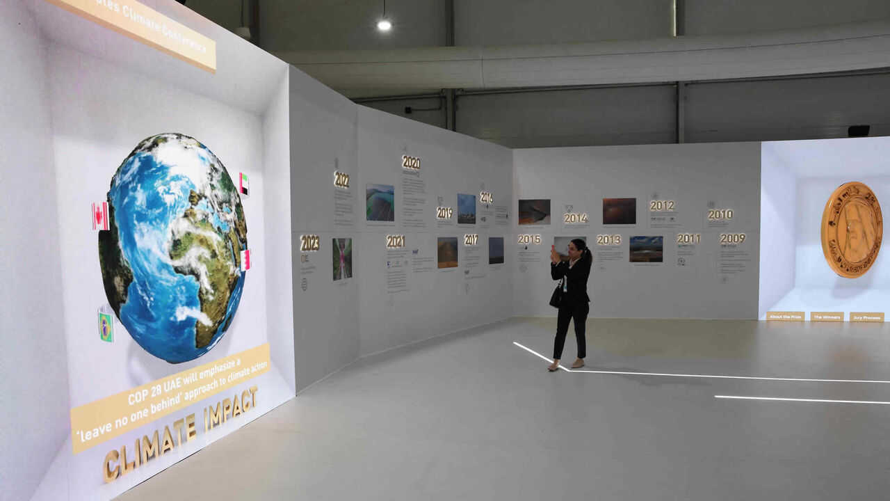 A woman takes a photo of a display at the Sharm el-Sheikh International Convention Center during the COP27 climate conference, Sharm el-Sheikh, Egypt, Nov. 15, 2022.
