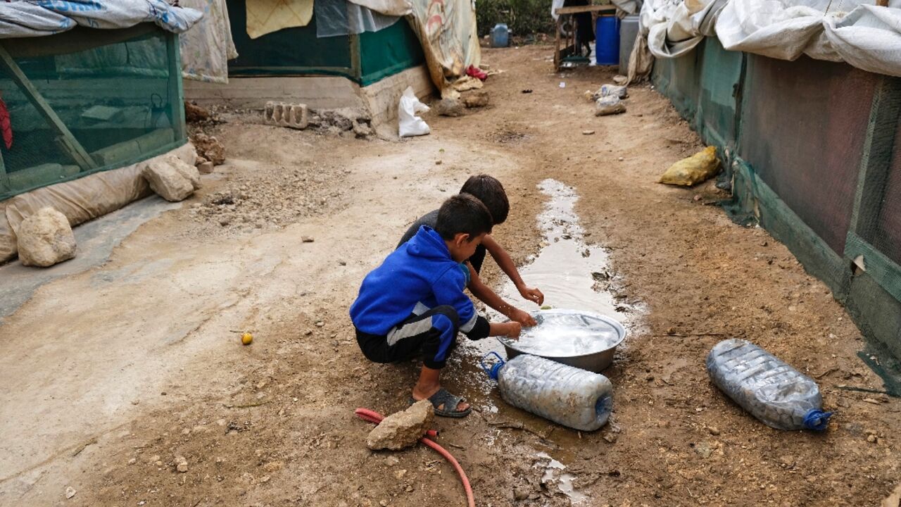 Amid an outbreak of cholera in the region, children rinse their hands at a camp for Syrian refugees in Talhayat, Lebanon