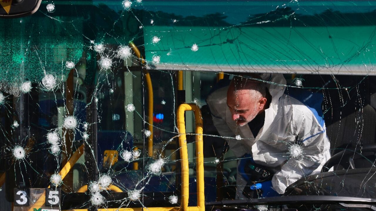 An Israeli forensic scientist inspects the inside of a bus damaged in one of the twin blasts that hit Jerusalem early Wednesday