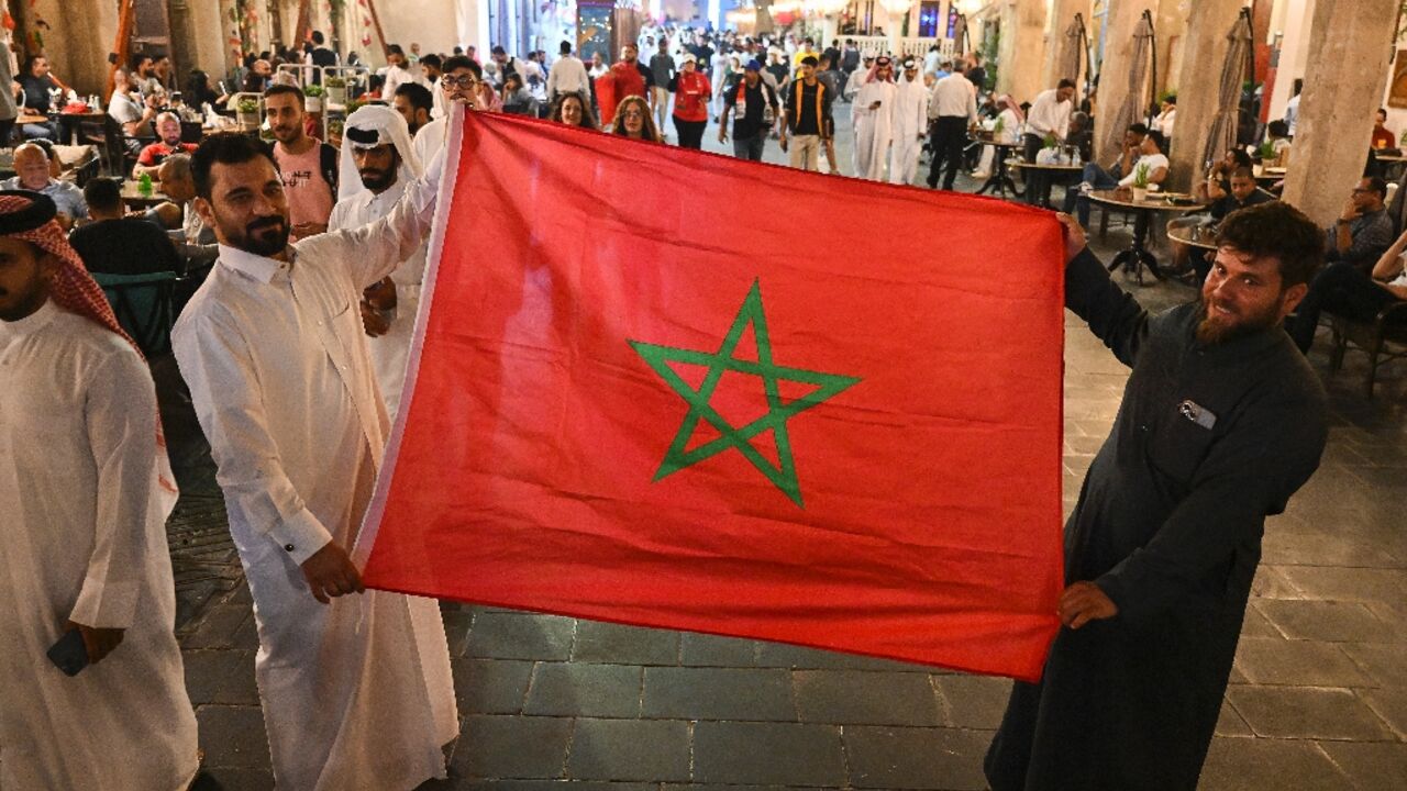 In Doha's Souq Waqif, Arab fans display Morocco's flag 