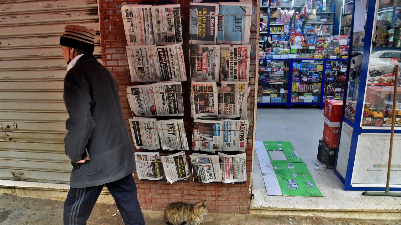 A man walks past a French-language daily newspaper stand displaying the final issue of Algerian French-language daily newspaper "Liberté" in Algeria's capital Algiers on April 14, 2022. (Photo by RYAD KRAMDI/AFP via Getty Images)