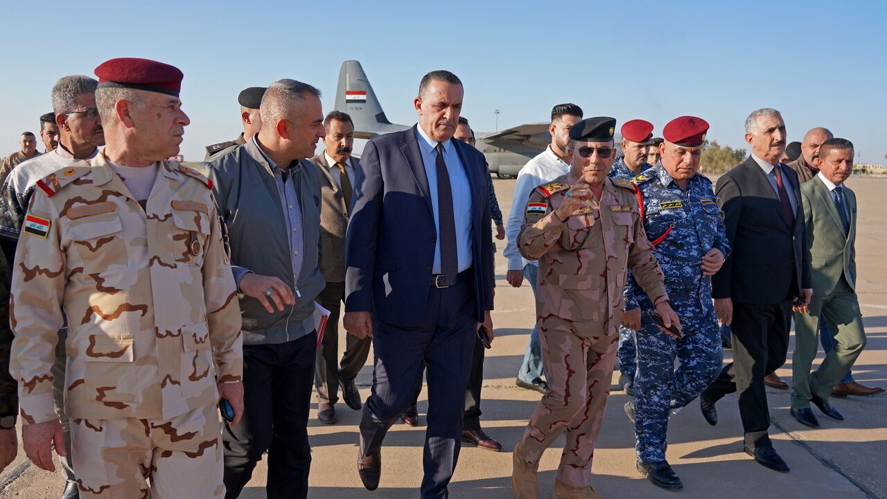 Governor Rakan al-Jabouri (C) attends the repatriation ceremony for members of Iraq's federal police members who were killed in suspected IS attack, at Kirkuk airport in northern Iraq on December 18, 2022. (Photo by MARWAN IBRAHIM/AFP via Getty Images)