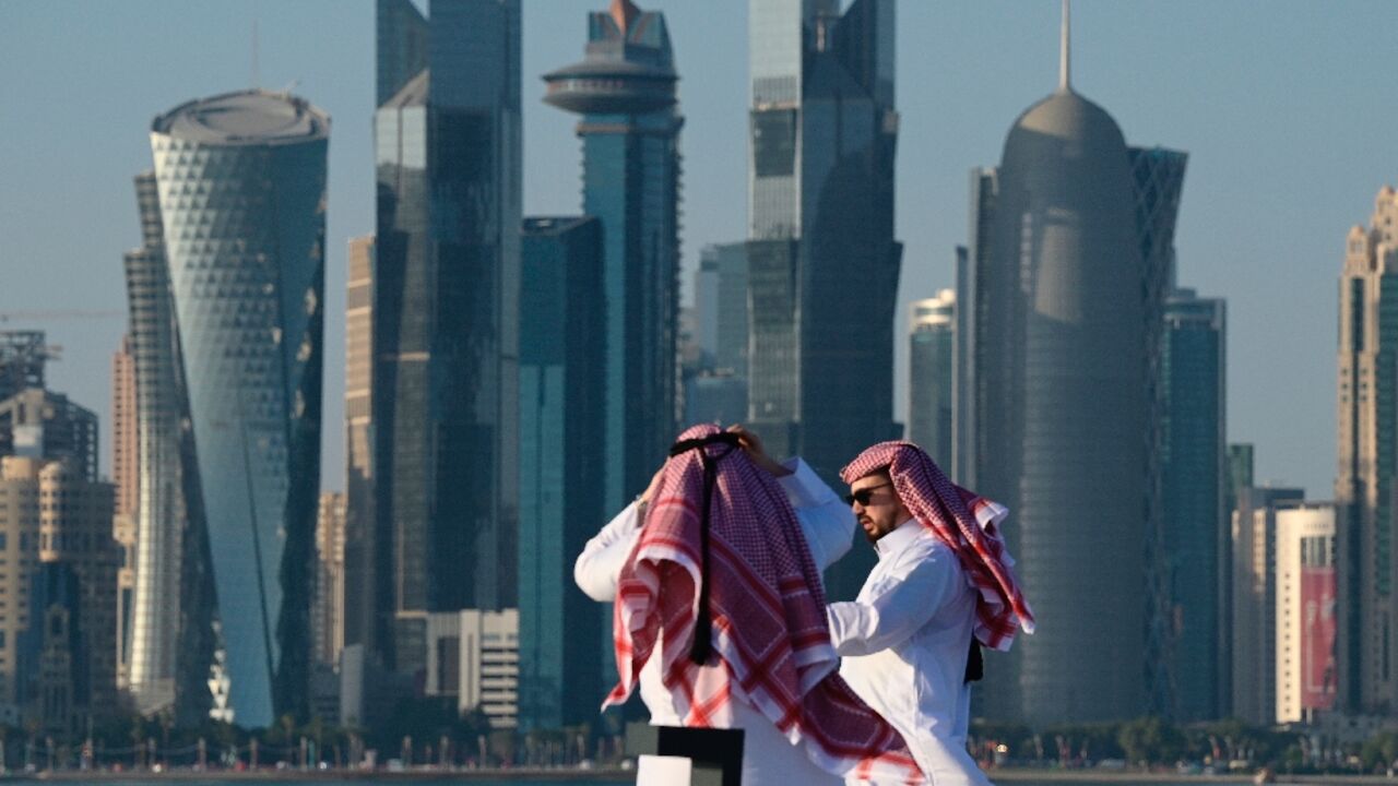 Two men walk along Doha's Corniche promenade on November 28, 2022 during Qatar 2022 World Cup