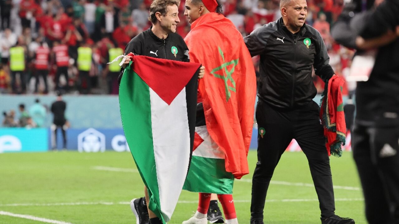 A member of Morocco's team holds a Palestinian flag after the team beat Spain