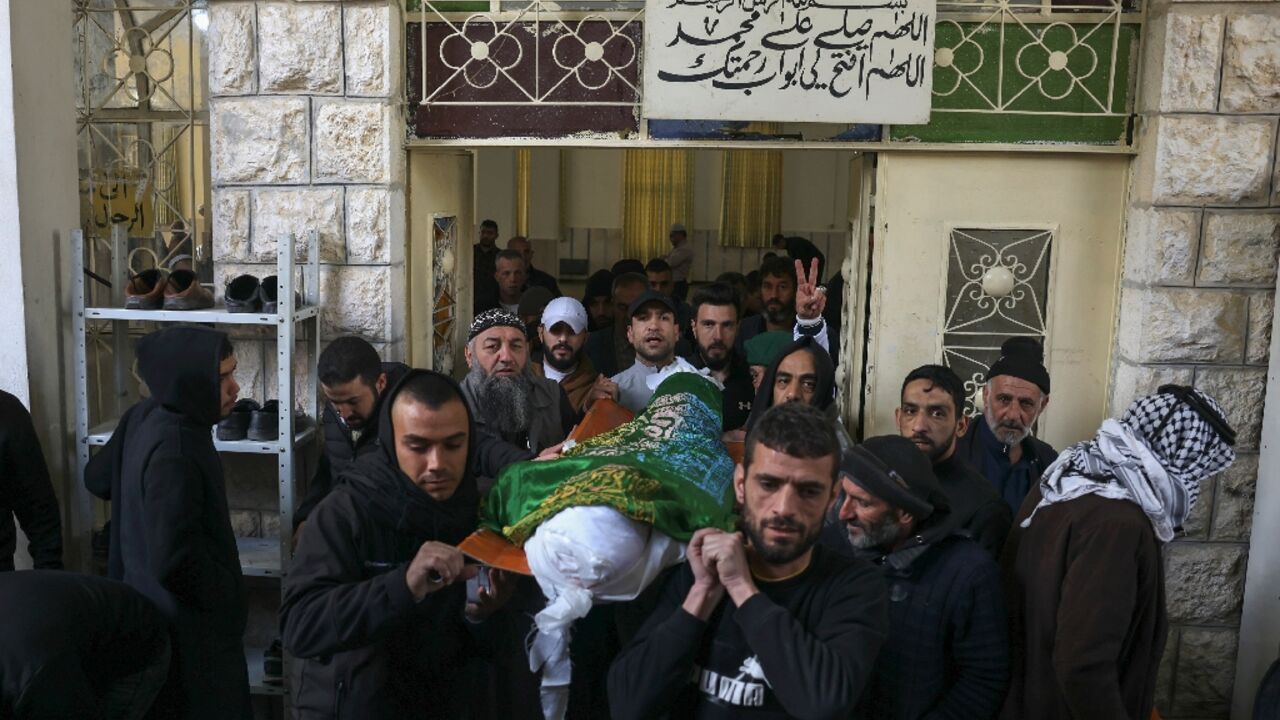 Palestinians carry the body of Nassim Abu Fouda who was killed by Israeli security forces early in the morning, during his funeral in Hebron city in the occupied West Bank, on January 30, 2023