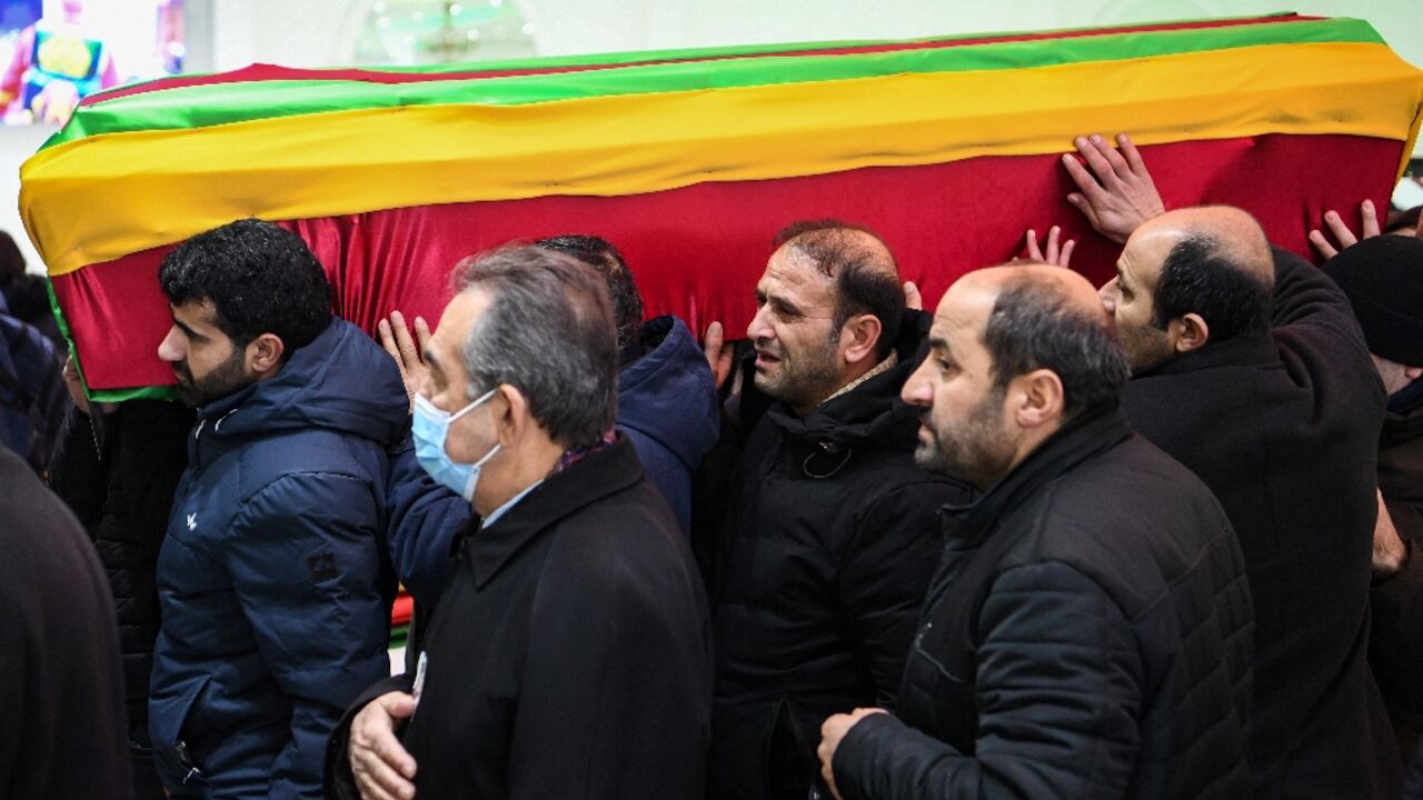 The coffins of the victims were draped in flags of Kurdish political causes