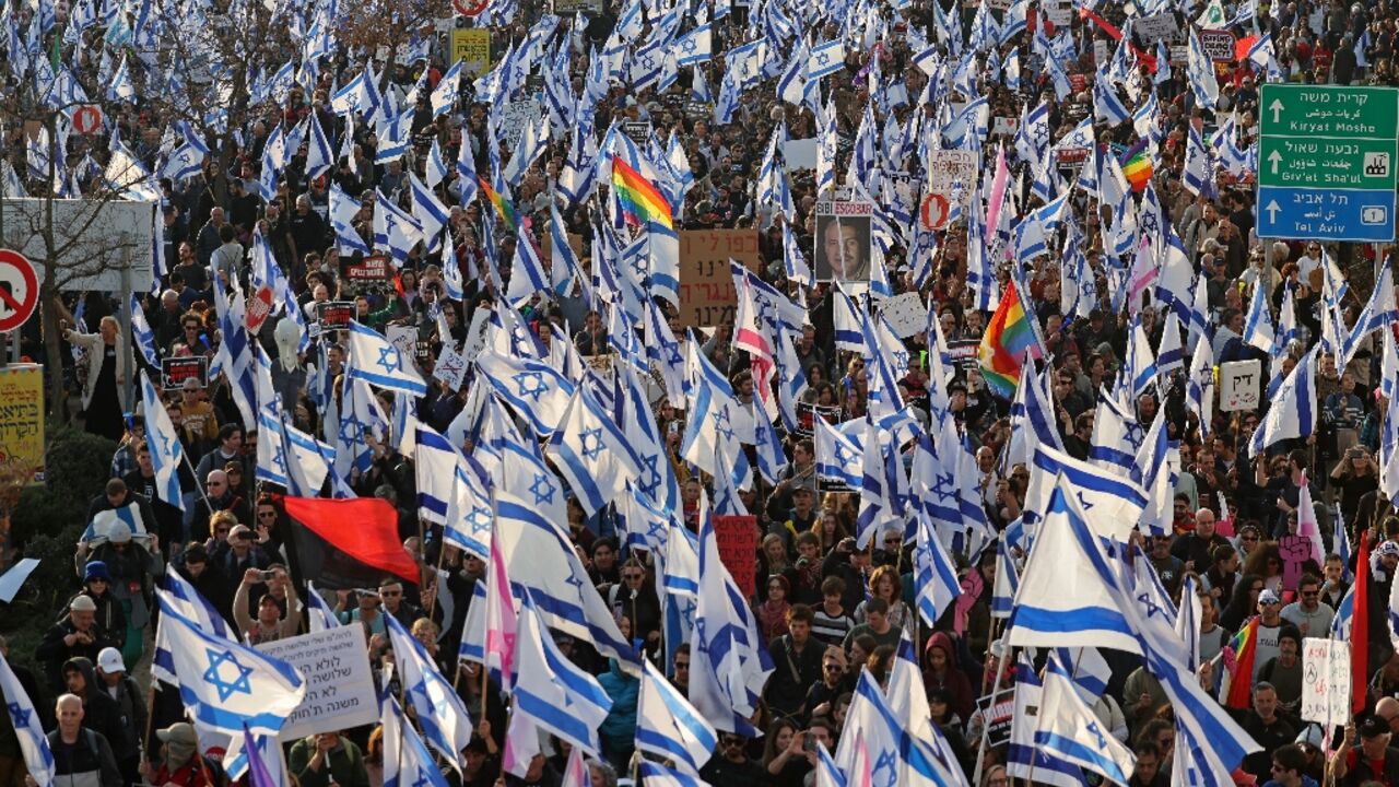 People rally waving Israeli flags against the government's judicial reform bill near parliament in Jerusalem on February 20