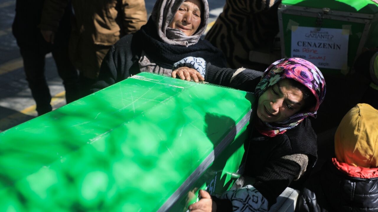 Relatives mourn victims by coffins in Gaziantep, near the epicentre of the strong quake which has killed more than 11,200 people in Turkey and Syria 