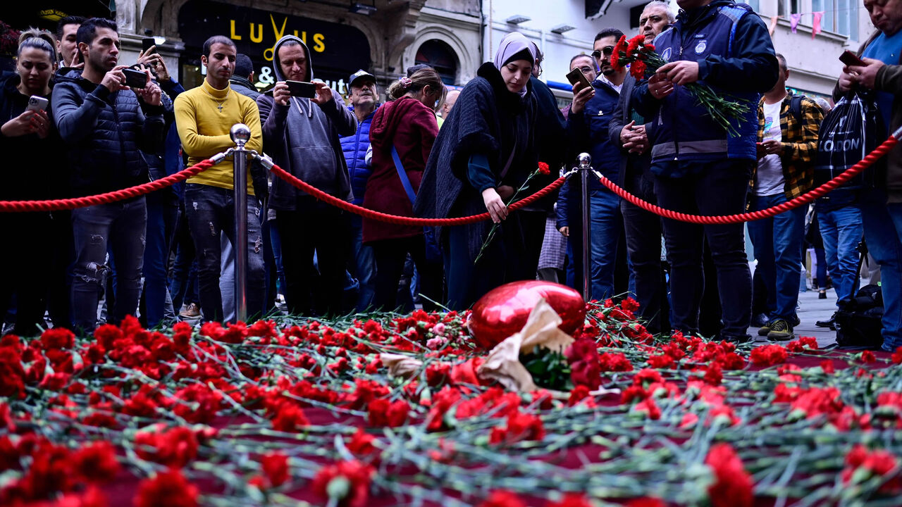 People lay flowers at a makeshift memorial for the victims of the Nov. 13 explosion at the busy shopping street of Istiklal, Istanbul, Turkey, Nov. 14, 2022.