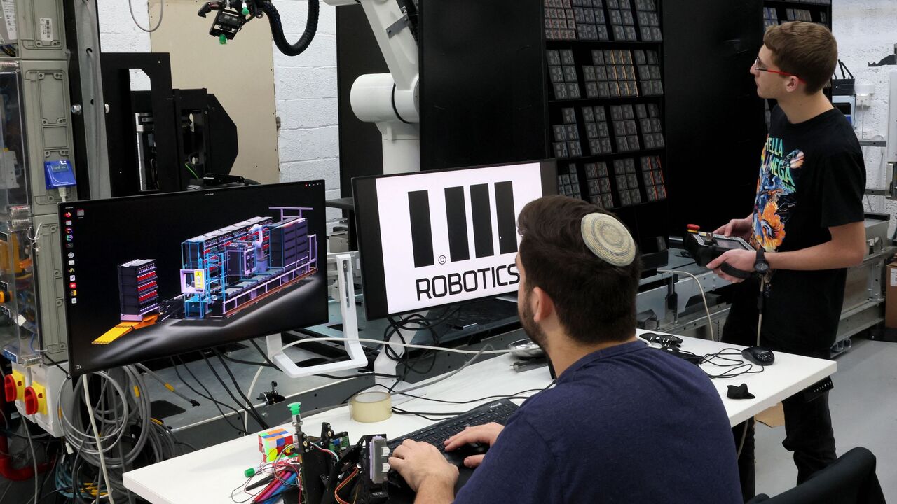 Technicians work at the headquarters of the Israeli company 1MRobotics, in the Israeli coastal city of Tel Aviv on, January 11, 2023. - Behind a seemingly ordinary storefront in Tel Aviv, the Israeli company is speeding up online shopping by replacing staff with robots that manoevure around small, streetside storerooms. (Photo by JACK GUEZ / AFP) (Photo by JACK GUEZ/AFP via Getty Images)