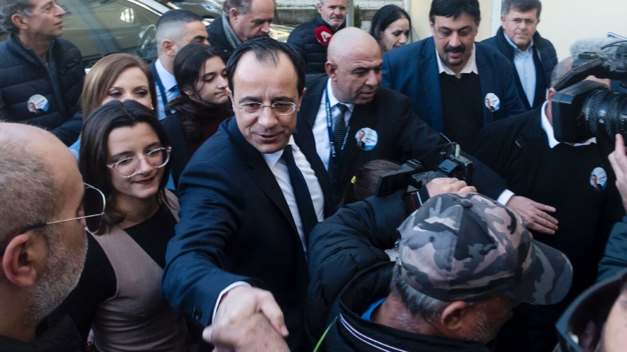 Former Cyprus foreign minister and presidential candidate Nikos Christodoulides greets supporters after casting his ballot for the presidential elections in the western Paphos district