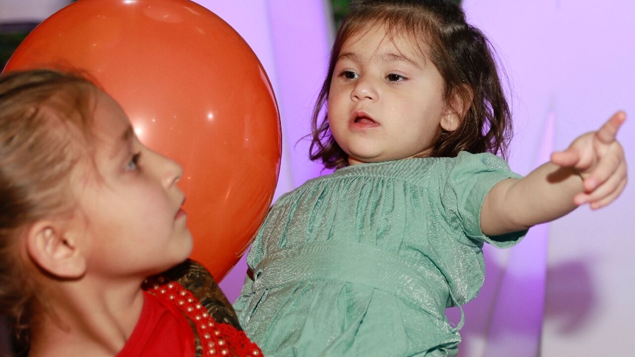 Afghan toddler Maryam, who was bundled onto an evacuation flight after her parents were killed in a huge bomb blast at Kabul airport in 2021, is reunited with her family and seen held by one of her sisters at an orphanage in Doha