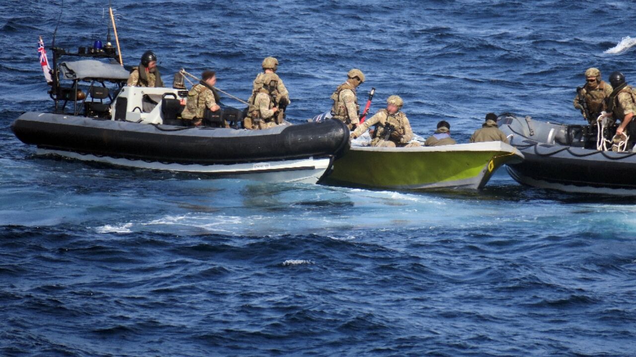 British marines remove Iranian weapons found aboard a suspected smuggling boat intercepted in the Gulf of Oman on February 23