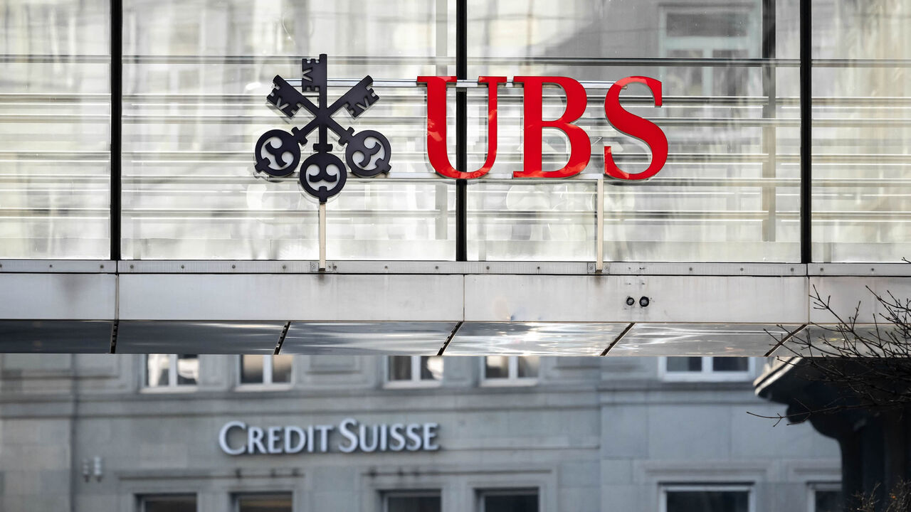 A sign and logo of Credit Suisse bank is seen beneath a sign of Swiss bank UBS, Zurich, Switzerland, March 20, 2023.