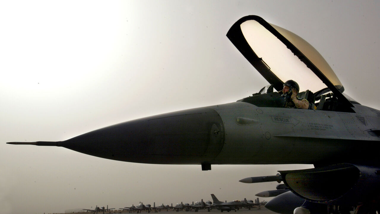An F-16 pilot from an airbase in Saudi Arabia gets ready to disembark from his aircraft after he was diverted to Kuwait because of bad weather after his mission into Iraq March 26, 2003 as Operation Iraqi Freedom continues after a pause in the air campaign due to bad weather. (Photo by Paula Bronstein/Getty Images)