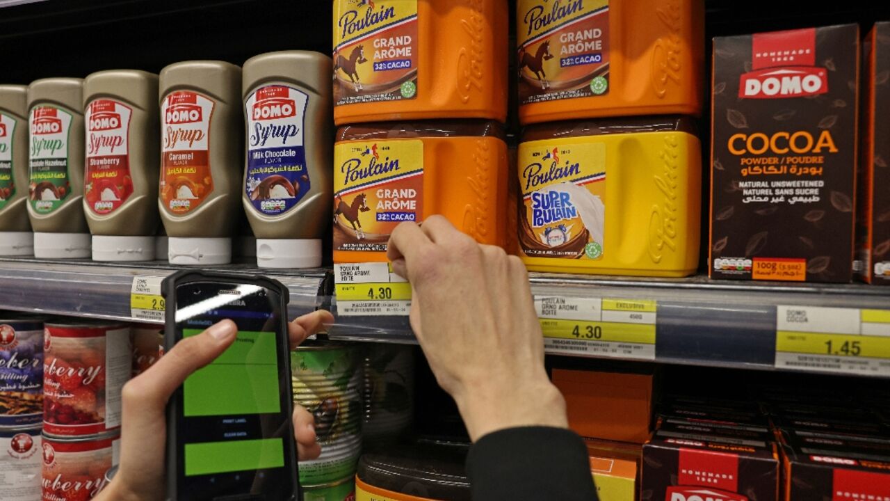 A Lebanon supermarket worker changes the price of products after shops began pricing goods in USD while the local currency took a new plunge