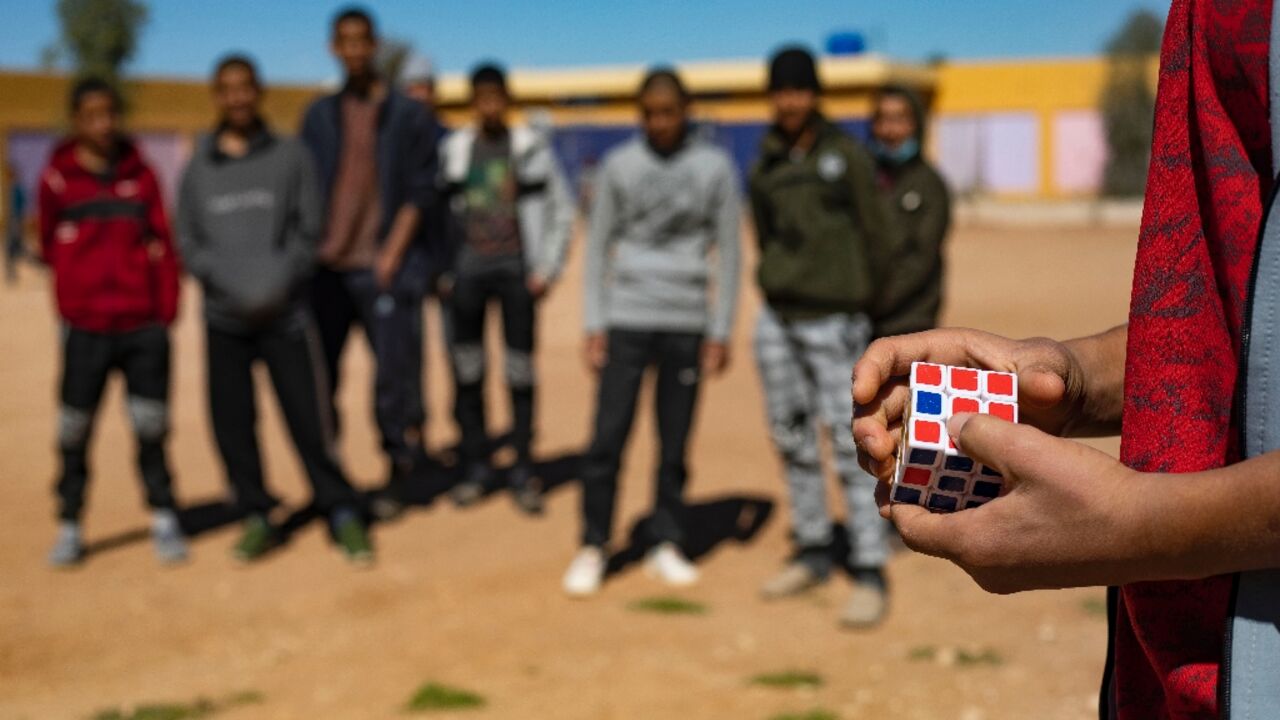 A child of a foreign Islamic State group (IS) fighter holds a Rubik's Cube in a playground at the Orkesh rehabilitation centre in northeastern Syria
