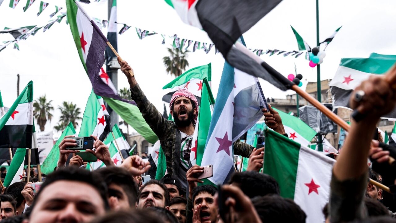 Syrian opposition supporters rally to mark the 12th anniversary of the start of the uprising against President Bashar al-Assad in the rebel-held northwestern city of Idlib on March 15, 2023