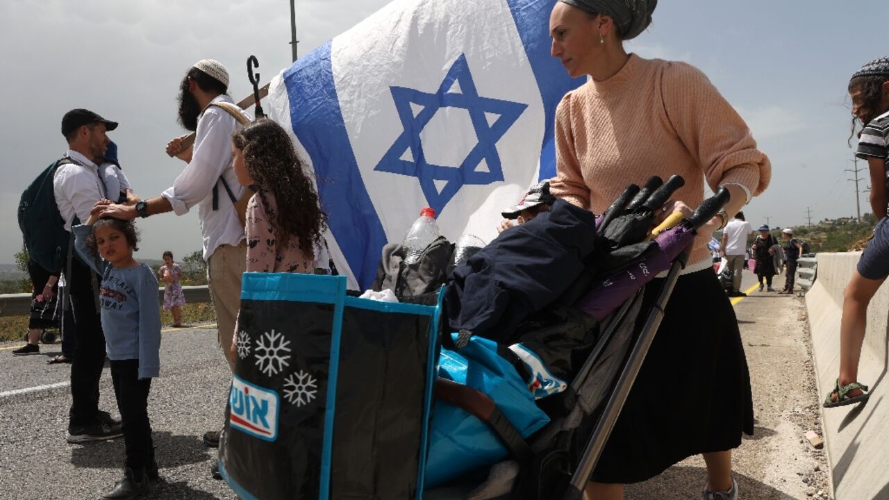 Israelis of all ages, including numerous armed men, walked to an outpost settlement built without approval from the state 