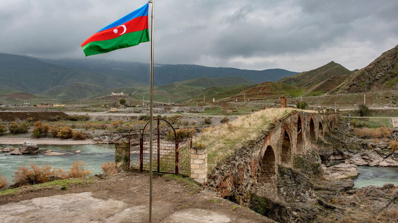 An Azerbaijani national flag flies next to the mediaeval Khudaferin bridge in Jebrayil district at the country's border with Iran - the territories recaptured from Armenian forces in fierce clashes over the disputed Nagorno-Karabakh region that were under Armenian separatists' control for nearly three decades, on December 9, 2020. (Photo by STRINGER / AFP) (Photo by STRINGER/AFP via Getty Images)