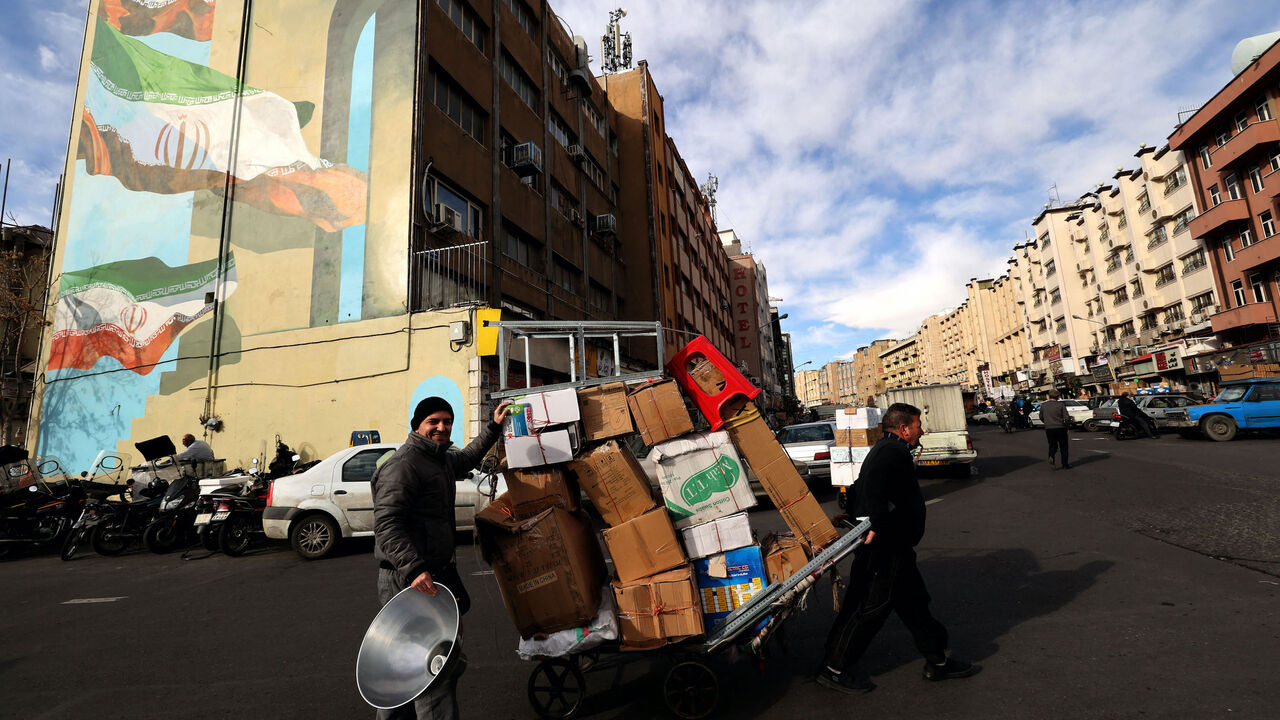 A man pulls a cart loaded with boxes in Tehran on February 21, 2023. - Iran's currency plunged to new lows on January 20 amid fresh European Union sanctions, crossing the psychologically important rate of 500,000 rials to a dollar in foreign exchange markets. (Photo by ATTA KENARE / AFP) (Photo by ATTA KENARE/AFP via Getty Images)