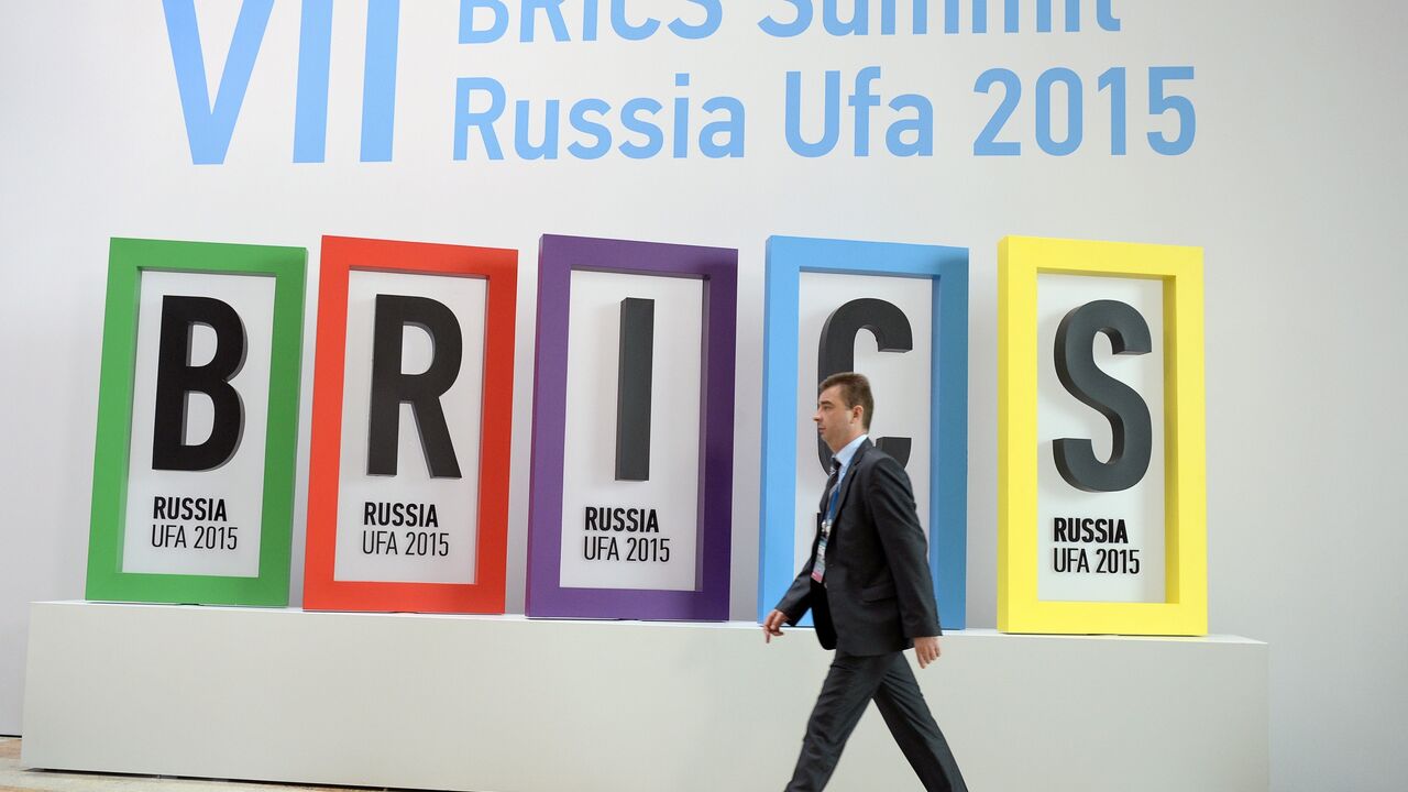 A man passes the BRICS summit logo at a hall in Ufa on July 9, 2015 prior to the start of the 7th BRICS summit. AFP PHOTO / ALEXANDER NEMENOV (Photo credit should read ALEXANDER NEMENOV/AFP via Getty Images)