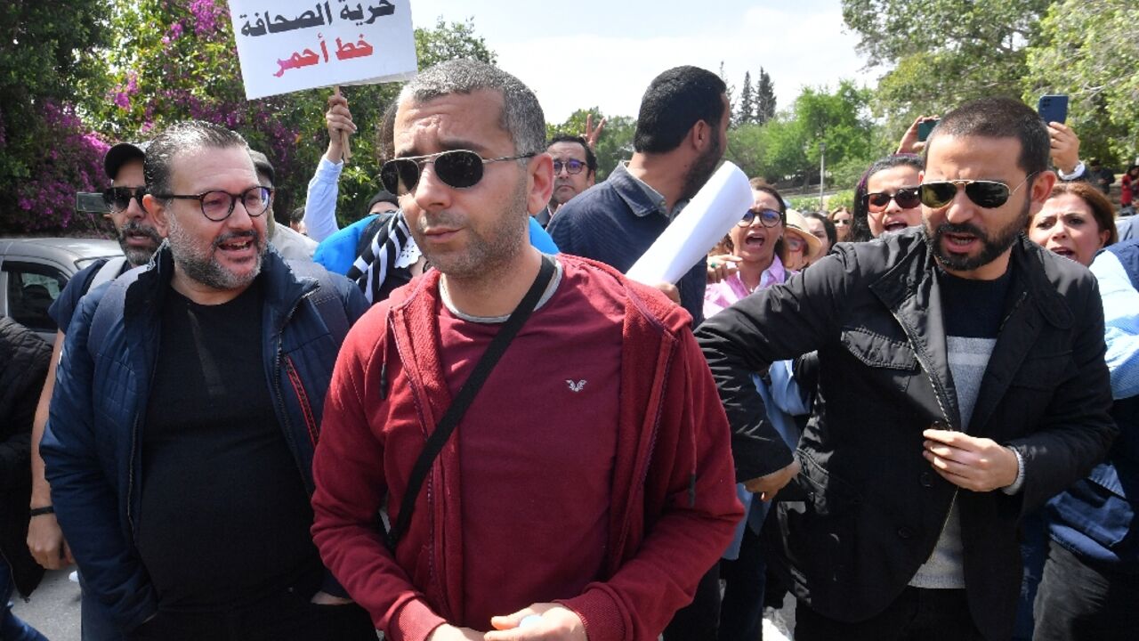 Haythem El Mekki (C) and Elyes Gharbi (L) surrounded by protesters in Tunis 