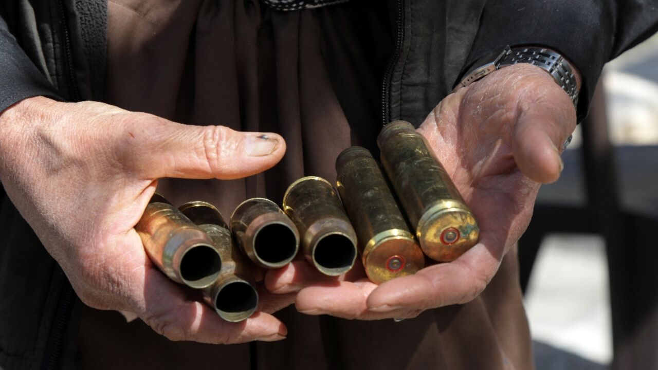 Moustafa Ahmed shows bullet casings collected after one of the many firefights near his home
