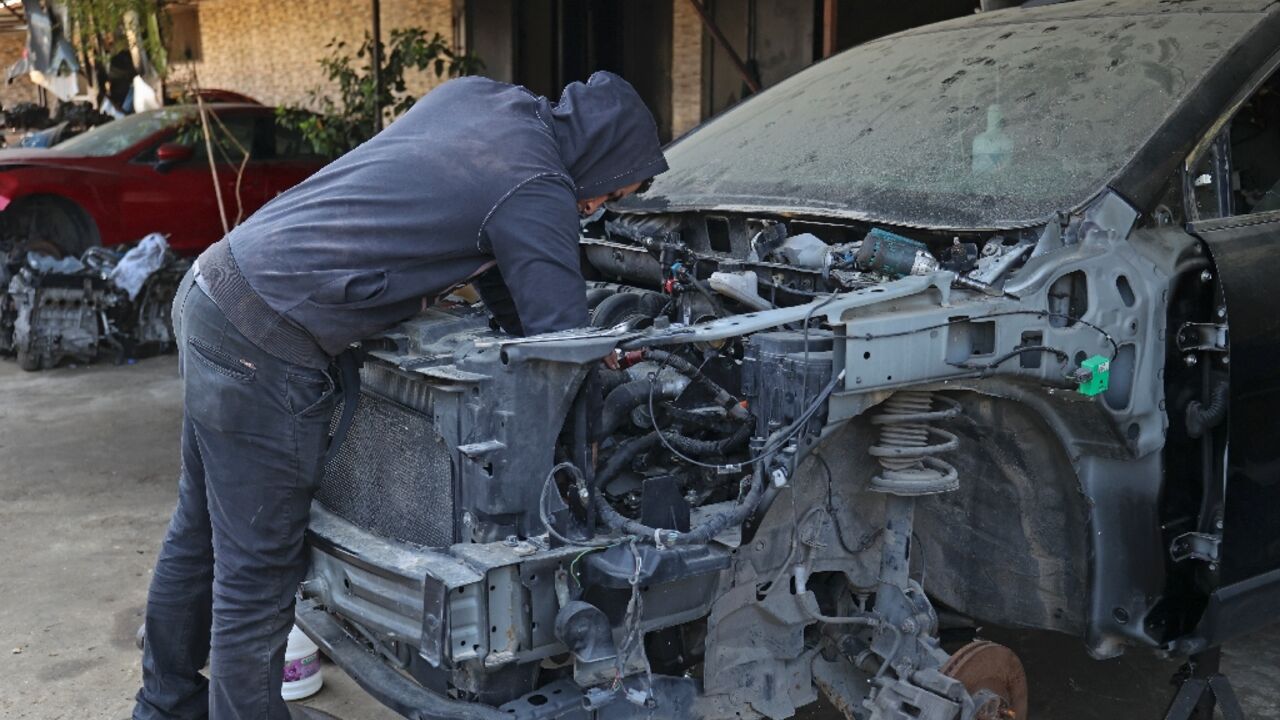 A soldier works at a garage in the Lebanese port city of Tripoli as a side hustle to make ends meet