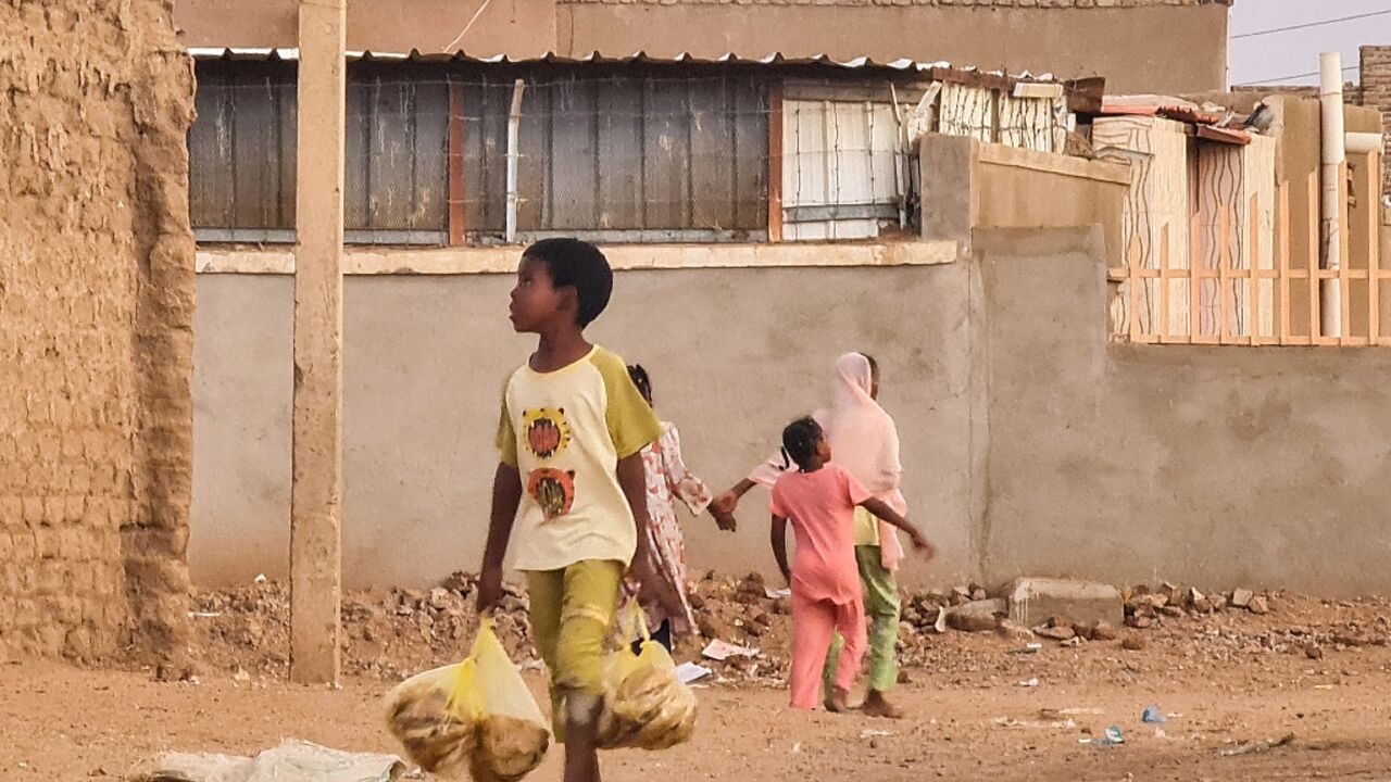 A child carries bread in Khartoum, where the war has broad shortages of essential goods