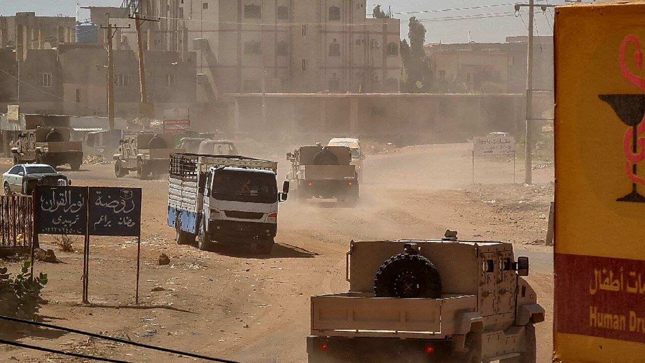 Sudanese army armoured vehicles drive in Khartoum, after paramalitaries seized the Central Reserve police headquarters in the city's south