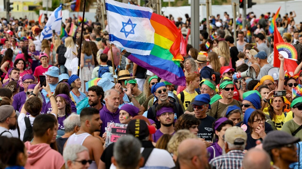 People march with rainbow and Israeli flags during the annual Pride Parade in Tel Aviv