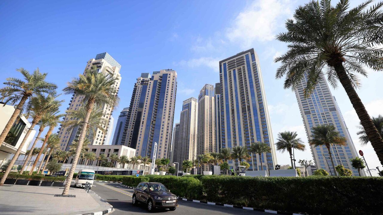 Cars drive along a street in front of high-rise buildings in Dubai on Feb. 18, 2023.