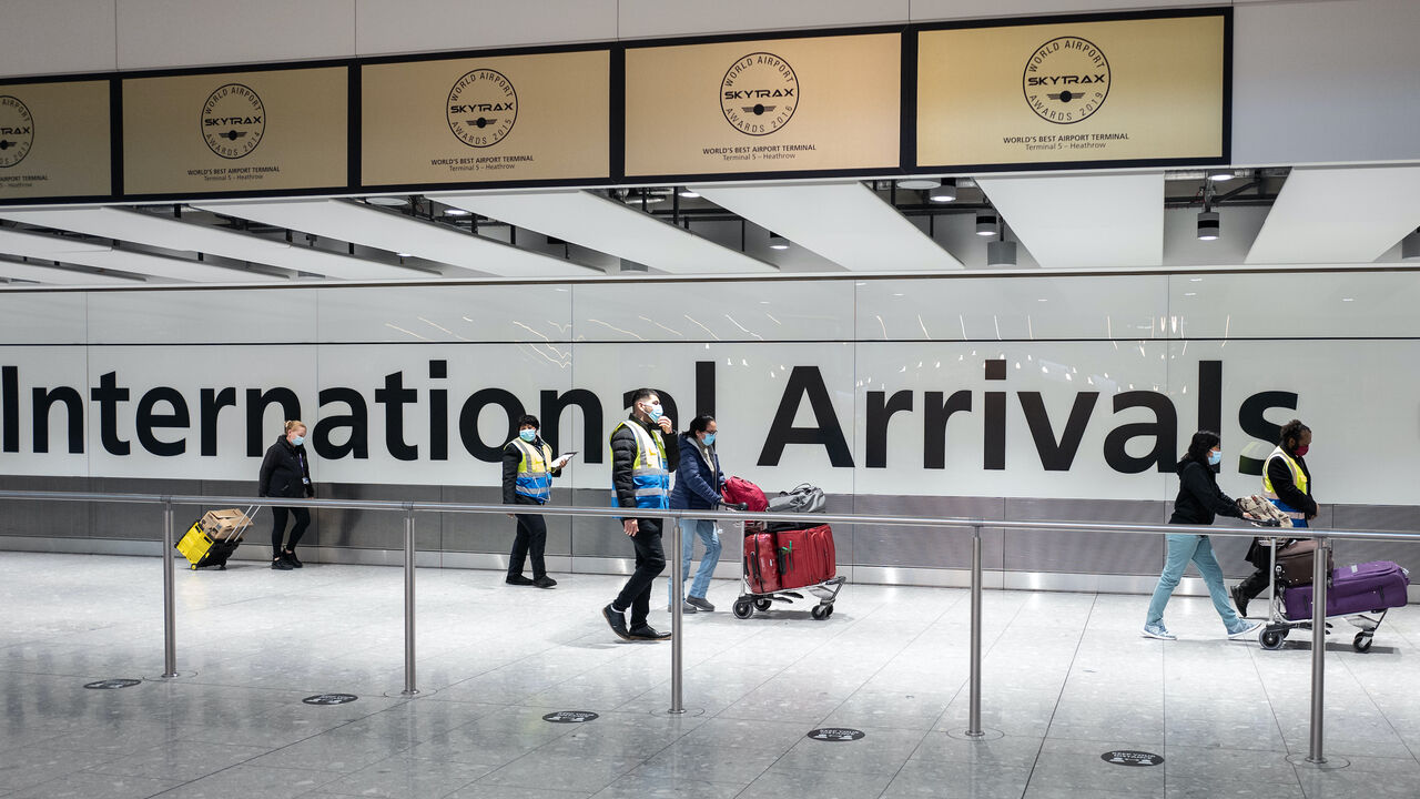 Passengers traveling from one of the countries on the "red list" are escorted through the arrivals area of terminal 5 of Heathrow airport and onto a waiting coach, on Feb. 16, 2021 in London, England. 