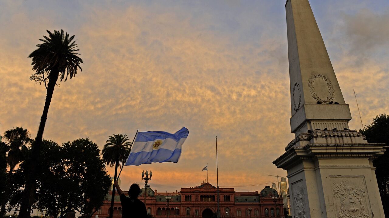 A man holds up an Argentinian flag during a demo at Mayo square, in Buenos Aires on January 19, 2015, against the death of Argentine public prosecutor Alberto Nisman, who was found shot dead earlier, just days after accusing President Cristina Kirchner of obstructing a probe into a 1994 Jewish center bombing. Nisman, 51, who was just hours away from testifying at a congressional hearing, was found dead overnight in his apartment in the trendy Puerto Madero neighbourhood of the capital. "I can confirm that a