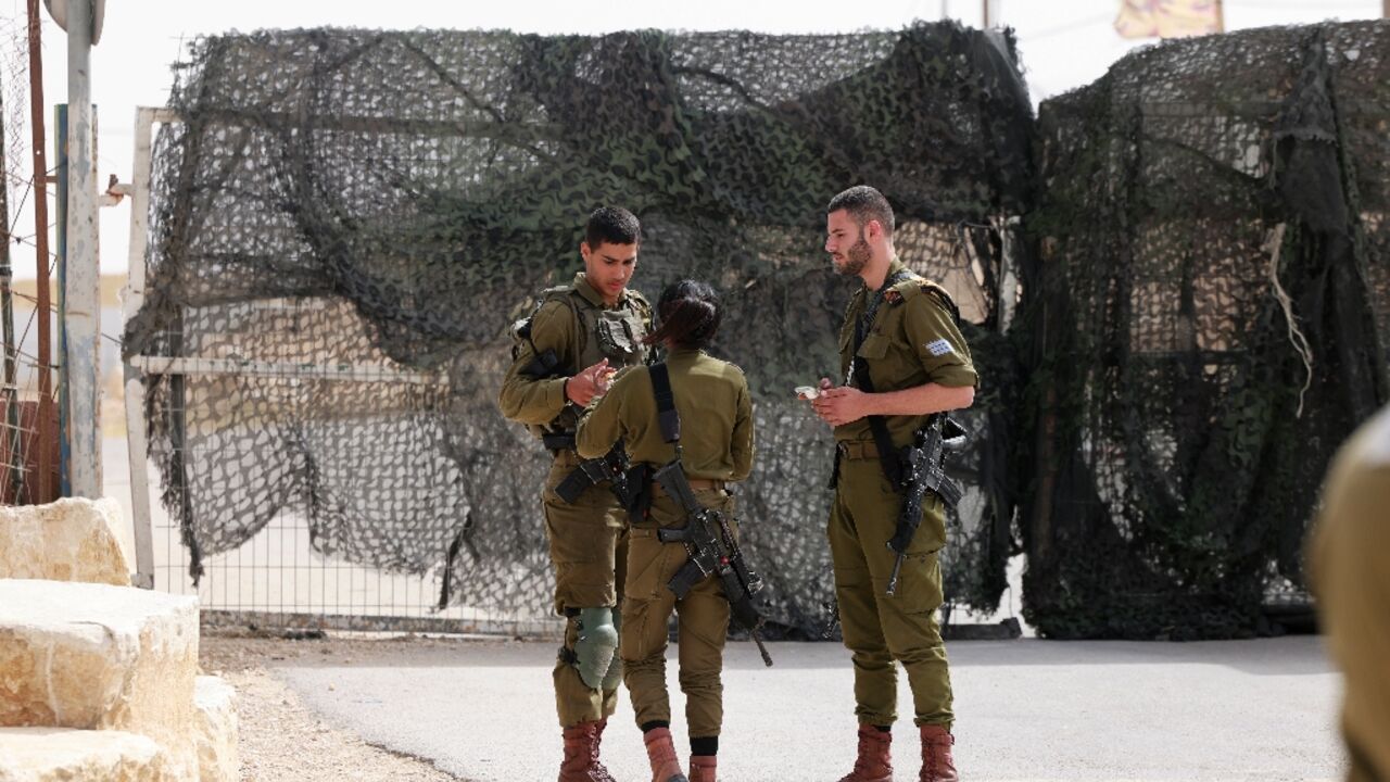 Israeli soldiers are pictured at the gate of the Mount Harif military base near the city of Mitzpe Ramon in Israel's southern Negev desert, adjacent to the border with Egypt