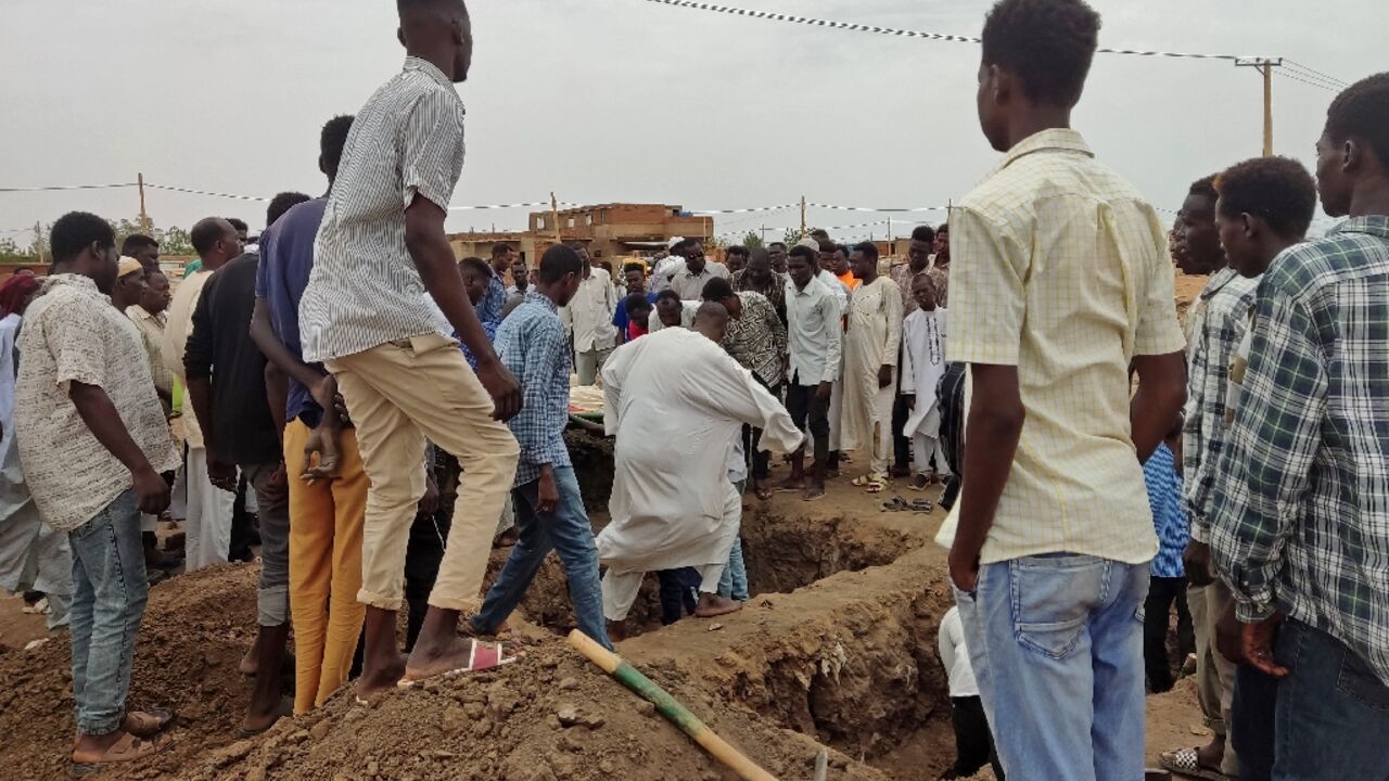 Mourners gather to bury victims killed of an artillery shell strike in southern Khartoum