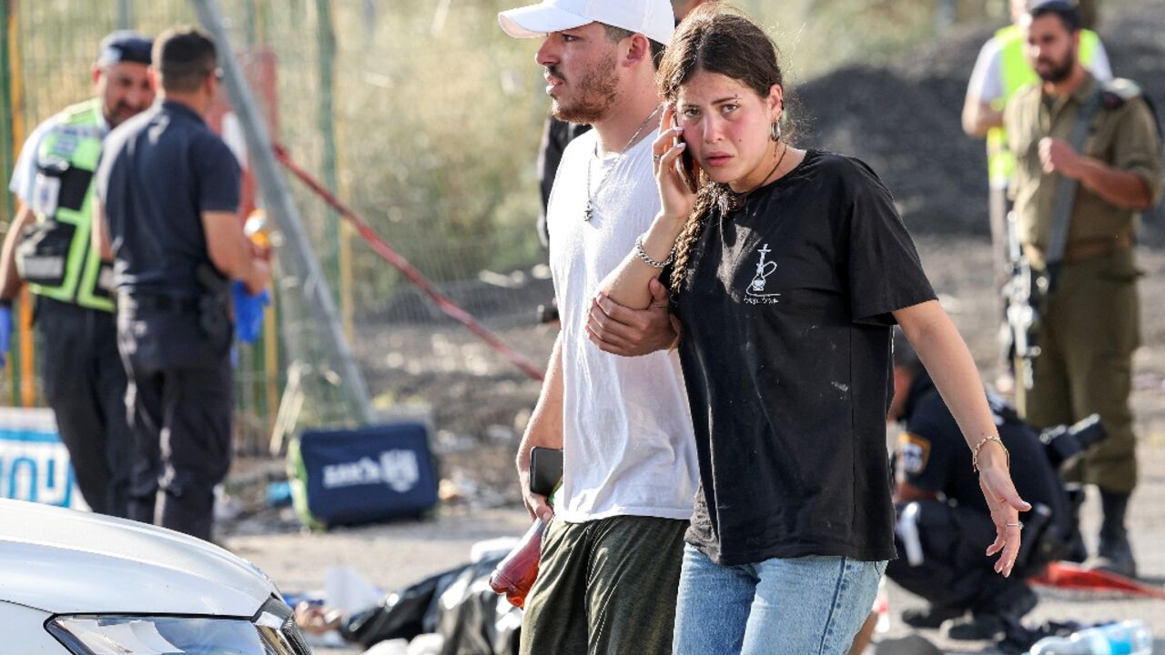 A man and a woman walk at the scene of a deadly attack near the Jewish settlement of Eli in the north of the occupied West Bank